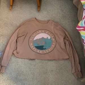 a cropped beige sweatshirt with slightly baggy sleeves and a warm fuzzy inside